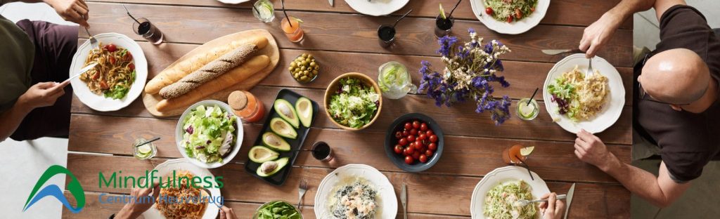 Blog eten en mindfulness. Foto van mensen aan een tafel die eten. Allerlei hapjes